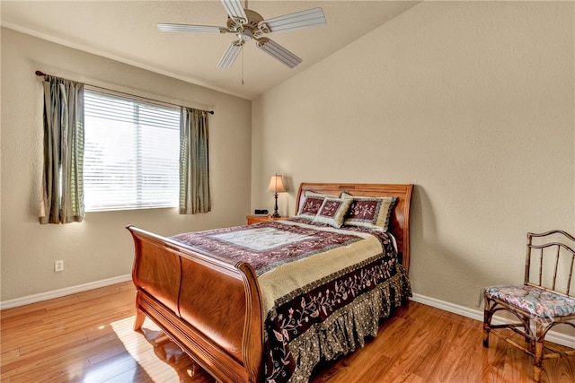 bedroom featuring ceiling fan, light hardwood / wood-style floors, and vaulted ceiling