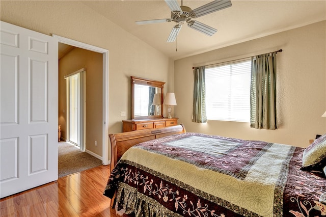 bedroom with hardwood / wood-style flooring, ceiling fan, and lofted ceiling