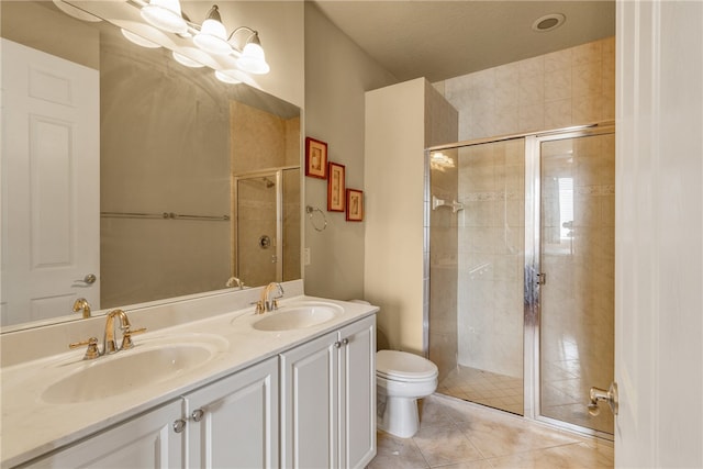 bathroom featuring tile patterned flooring, vanity, toilet, and an enclosed shower