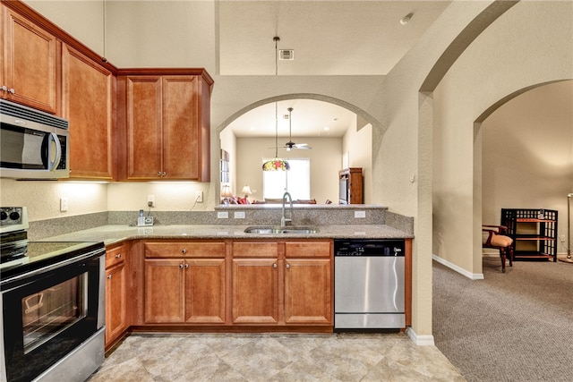 kitchen with ceiling fan, sink, hanging light fixtures, stainless steel appliances, and light colored carpet