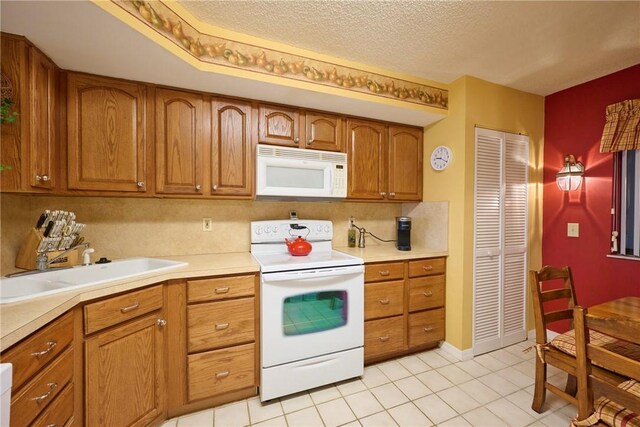 kitchen featuring light tile patterned flooring, sink, a textured ceiling, white appliances, and decorative backsplash