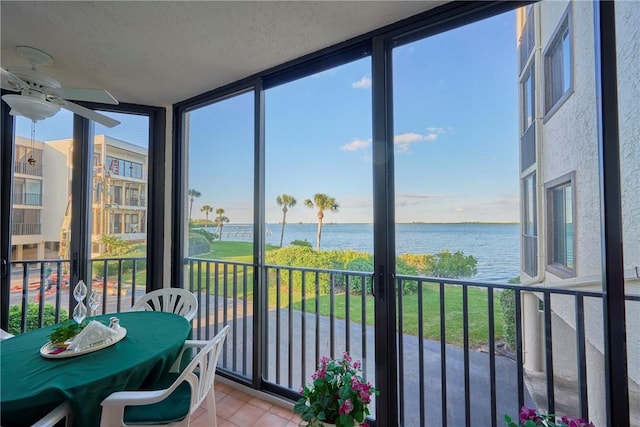 sunroom / solarium featuring a water view, ceiling fan, and a wealth of natural light