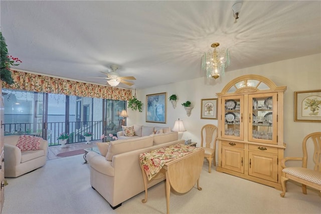 carpeted living room featuring ceiling fan with notable chandelier