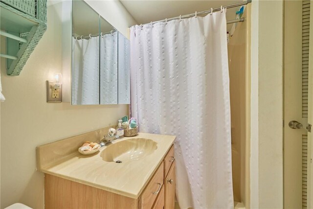 bathroom featuring vanity and curtained shower