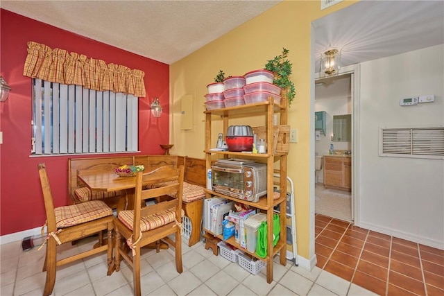 tiled dining space with a textured ceiling