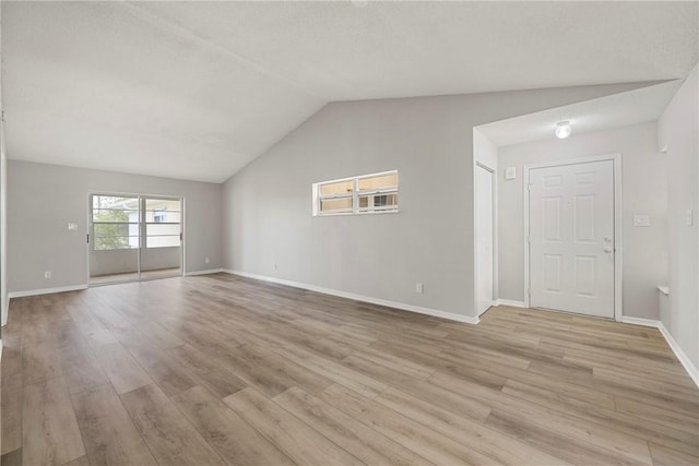 unfurnished living room featuring lofted ceiling and light wood-type flooring