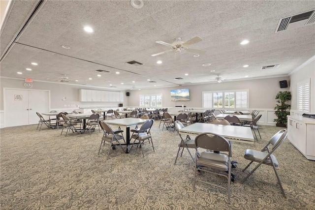 carpeted dining room featuring ceiling fan, ornamental molding, and a textured ceiling