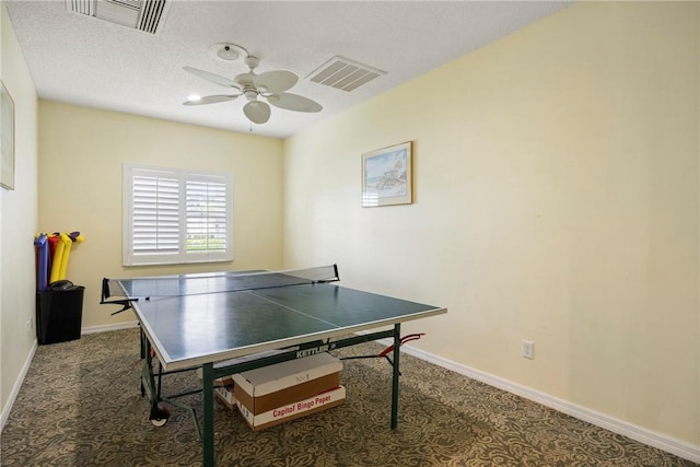 playroom featuring ceiling fan, carpet flooring, and a textured ceiling