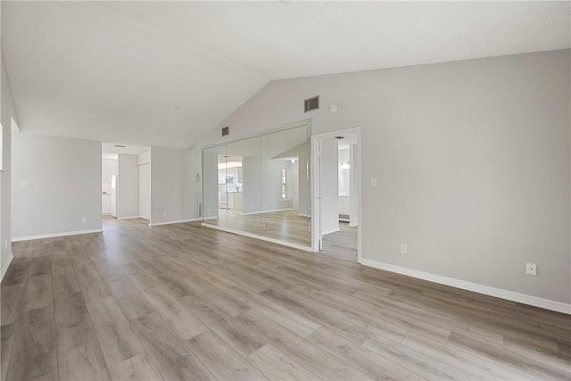 spare room with vaulted ceiling and light hardwood / wood-style flooring