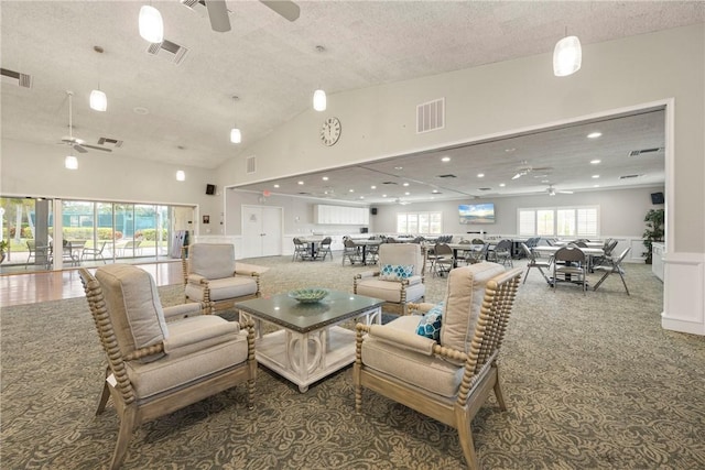 carpeted living room with a textured ceiling, ceiling fan, and a high ceiling