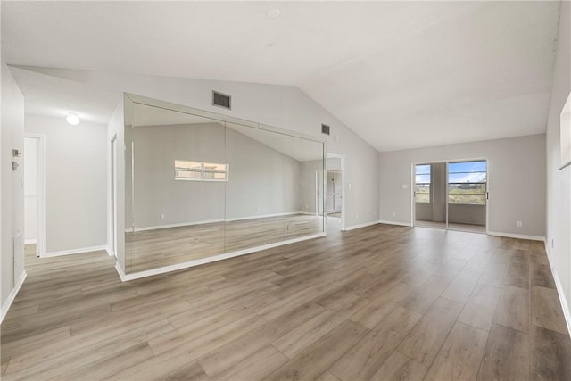 unfurnished living room featuring hardwood / wood-style flooring and vaulted ceiling