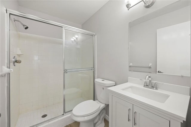 bathroom with an enclosed shower, vanity, and toilet