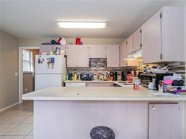 kitchen with white appliances, sink, decorative backsplash, light tile patterned floors, and kitchen peninsula