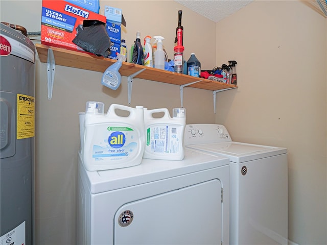 laundry room with a textured ceiling, washing machine and dryer, and water heater