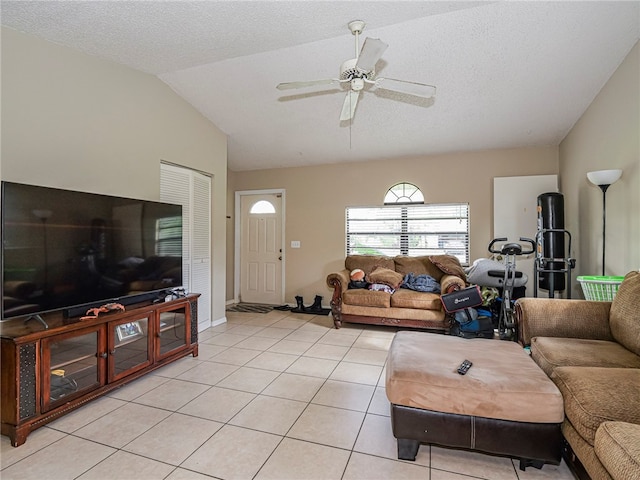 tiled living room featuring ceiling fan, a textured ceiling, and vaulted ceiling