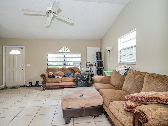 living room featuring lofted ceiling, ceiling fan, and light tile patterned floors