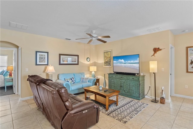 living room with light tile patterned floors, a textured ceiling, and ceiling fan