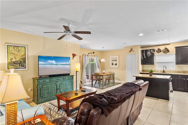 living room with light tile patterned flooring, ceiling fan, plenty of natural light, and sink