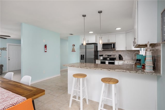 1203 Linmoor Cir NE, Palm Bay, FL 32907 - kitchen featuring stainless steel appliances, tasteful backsplash, a peninsula, light stone countertops, and a sink
