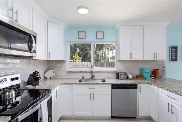 1203 Linmoor Cir NE, Palm Bay, FL 32907 - kitchen with appliances with stainless steel finishes, a sink, tasteful backsplash, and white cabinets