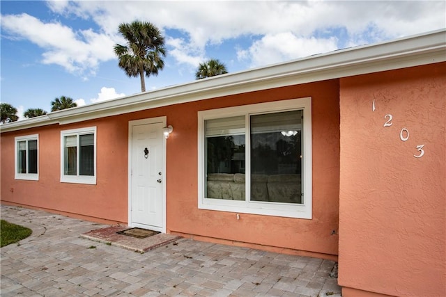 1203 Linmoor Cir NE, Palm Bay, FL 32907 - doorway to property featuring a patio and stucco siding