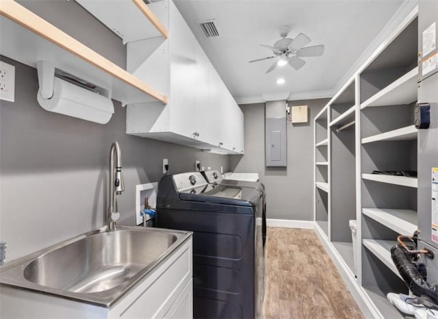 laundry area with sink, washing machine and dryer, cabinets, ceiling fan, and light hardwood / wood-style floors