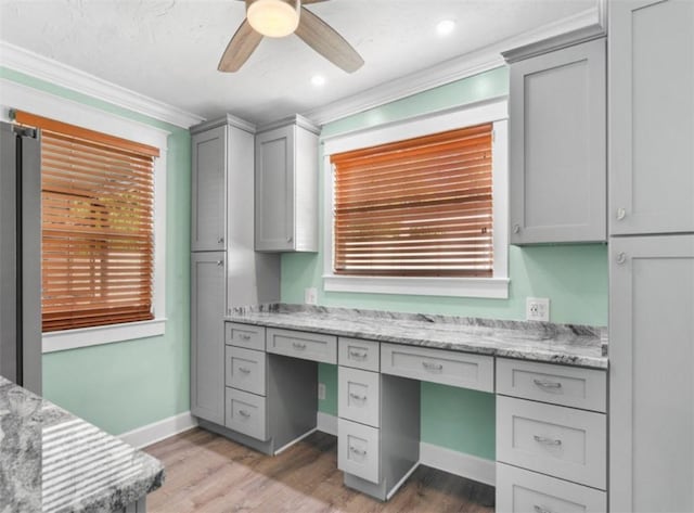 office featuring ornamental molding, built in desk, and light wood-type flooring