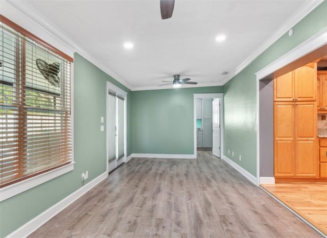 empty room with crown molding, light hardwood / wood-style floors, and ceiling fan