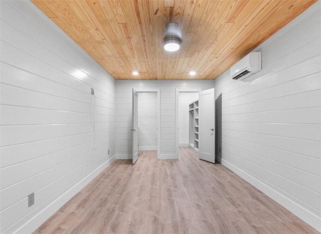 basement with a wall mounted air conditioner, wooden ceiling, and light hardwood / wood-style floors