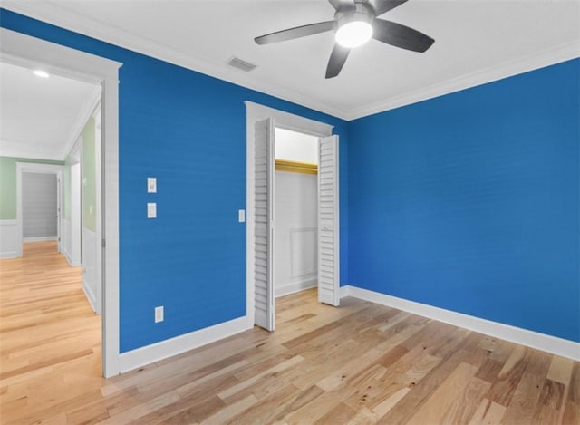 unfurnished bedroom with ornamental molding, a closet, and light wood-type flooring