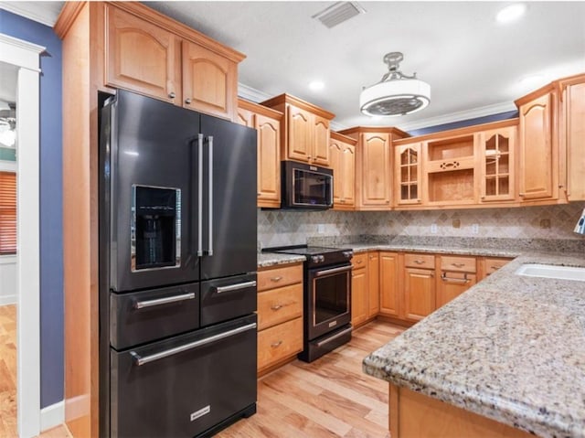 kitchen with sink, ornamental molding, black appliances, and light stone countertops