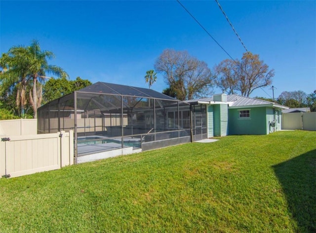 back of house with a yard, a lanai, and a fenced in pool