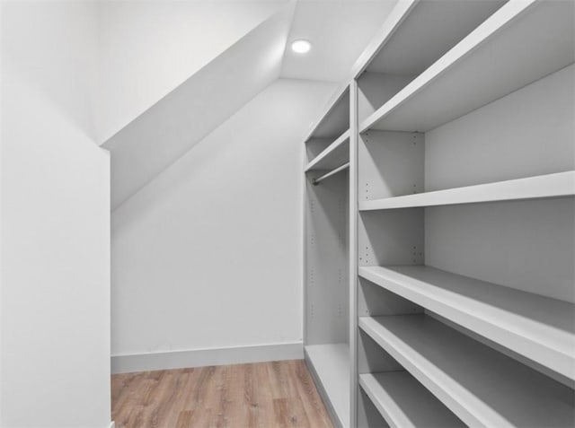 spacious closet with vaulted ceiling and hardwood / wood-style floors