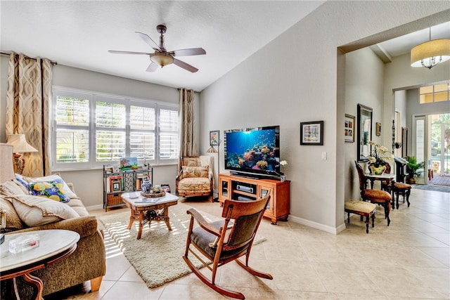 living room with ceiling fan, light tile patterned floors, a wealth of natural light, and vaulted ceiling