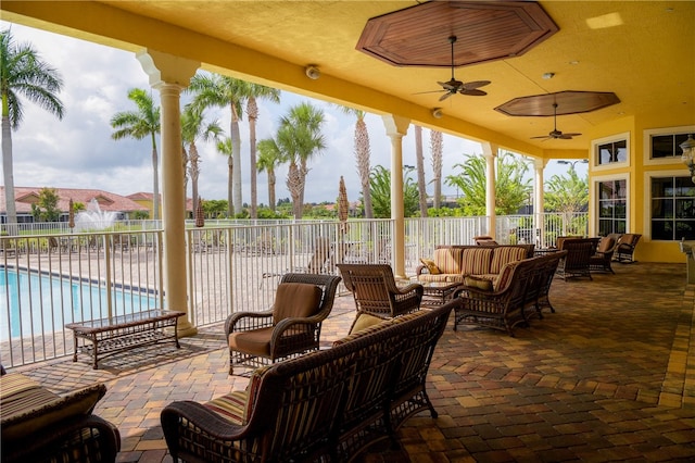 view of patio / terrace with an outdoor living space, ceiling fan, and a community pool