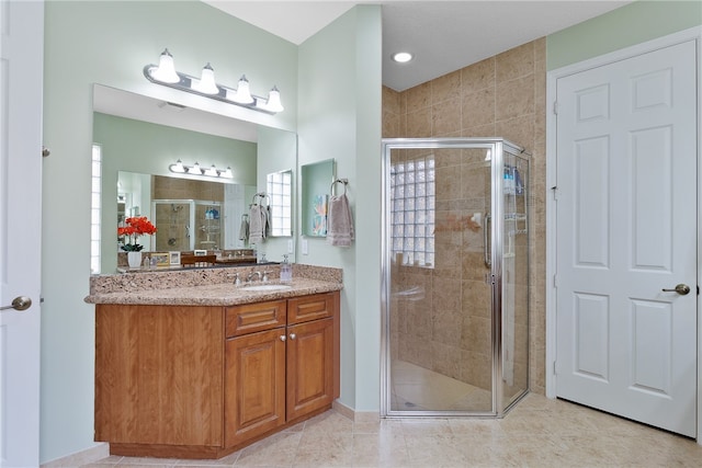 bathroom featuring tile patterned flooring, vanity, and a shower with shower door