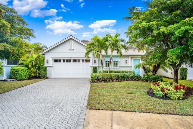 single story home with a garage and a front lawn