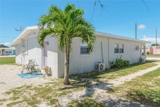 view of side of home featuring ac unit, a lawn, and a patio