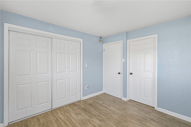 unfurnished bedroom featuring a closet and light hardwood / wood-style flooring