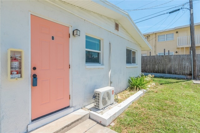 property entrance featuring ac unit and a yard