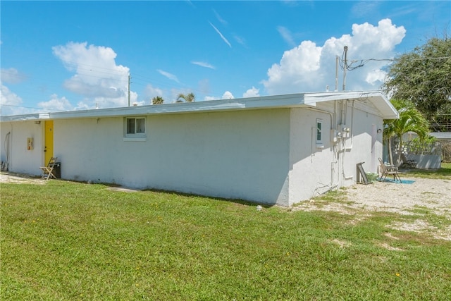 681 S Orlando Ave, Cocoa Beach, FL 32931 - view of side of property featuring stucco siding and a lawn