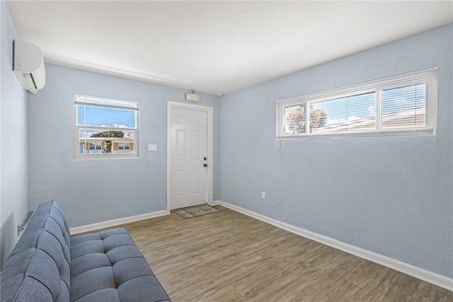 living room featuring hardwood / wood-style flooring and a wall mounted air conditioner