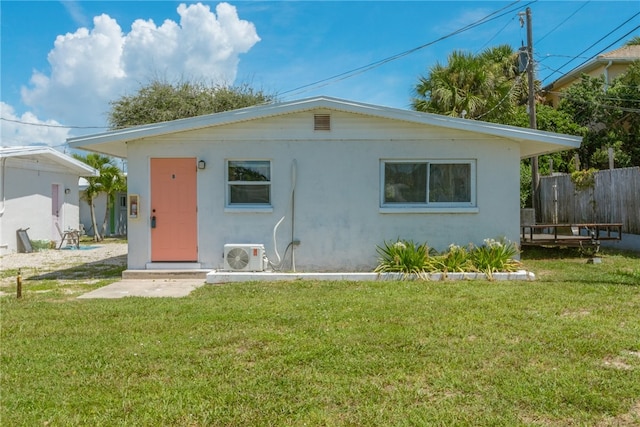 rear view of property featuring a yard and ac unit