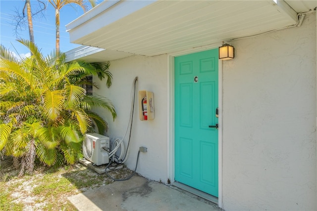 673 S Orlando Ave, Cocoa Beach, FL 32931 - property entrance with stucco siding and ac unit
