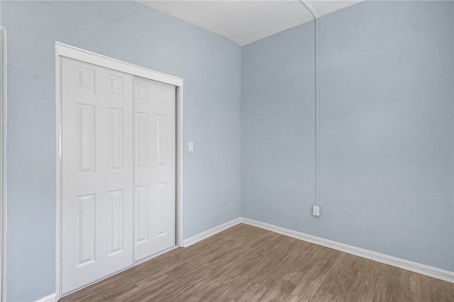 673 S Orlando Ave, Cocoa Beach, FL 32931 - unfurnished bedroom featuring wood finished floors, a closet, and baseboards