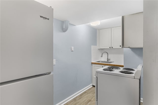 673 S Orlando Ave, Cocoa Beach, FL 32931 - kitchen with white appliances, a sink, white cabinetry, light wood-style flooring, and baseboards