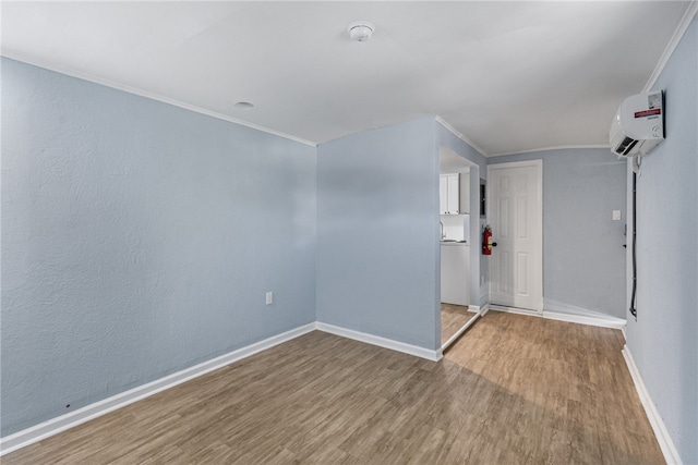 673 S Orlando Ave, Cocoa Beach, FL 32931 - empty room featuring wood finished floors, crown molding, baseboards, an AC wall unit, and a smoke detector