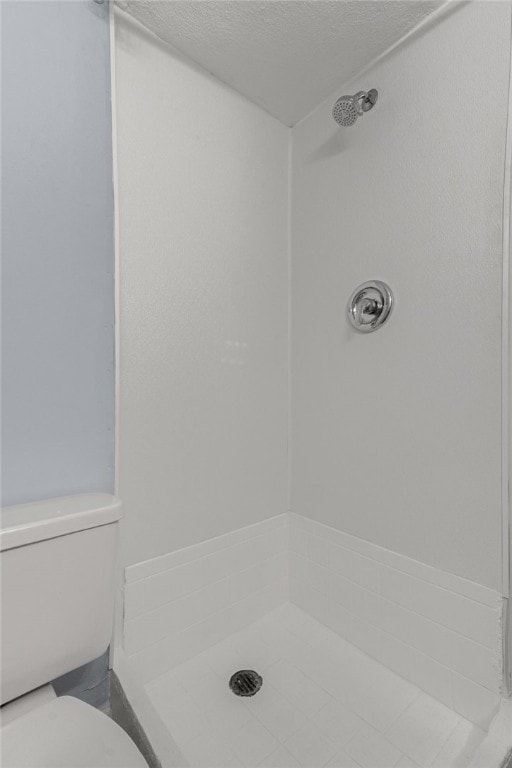 673 S Orlando Ave, Cocoa Beach, FL 32931 - bathroom featuring a shower, toilet, and a textured ceiling