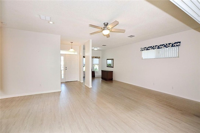 unfurnished living room featuring ceiling fan, light hardwood / wood-style floors, and a textured ceiling