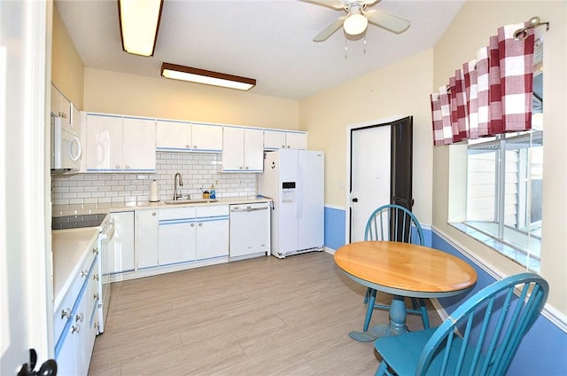 kitchen with sink, white cabinetry, light hardwood / wood-style flooring, white appliances, and decorative backsplash